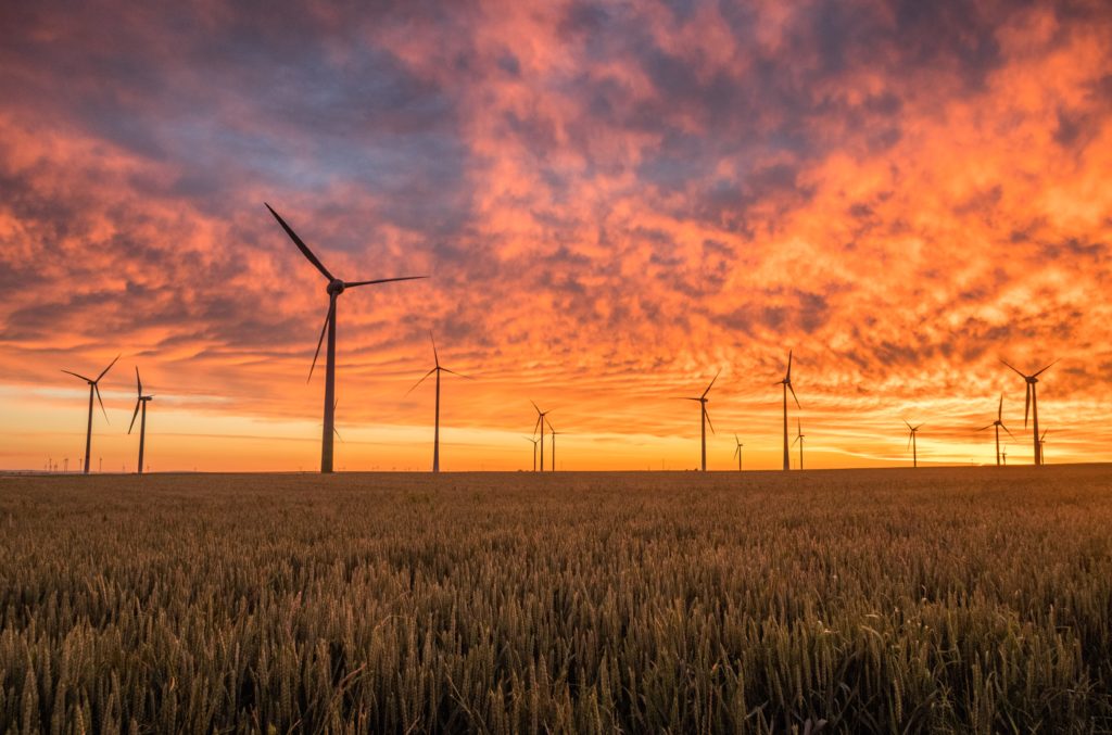 wind turbines against a deep red sunset