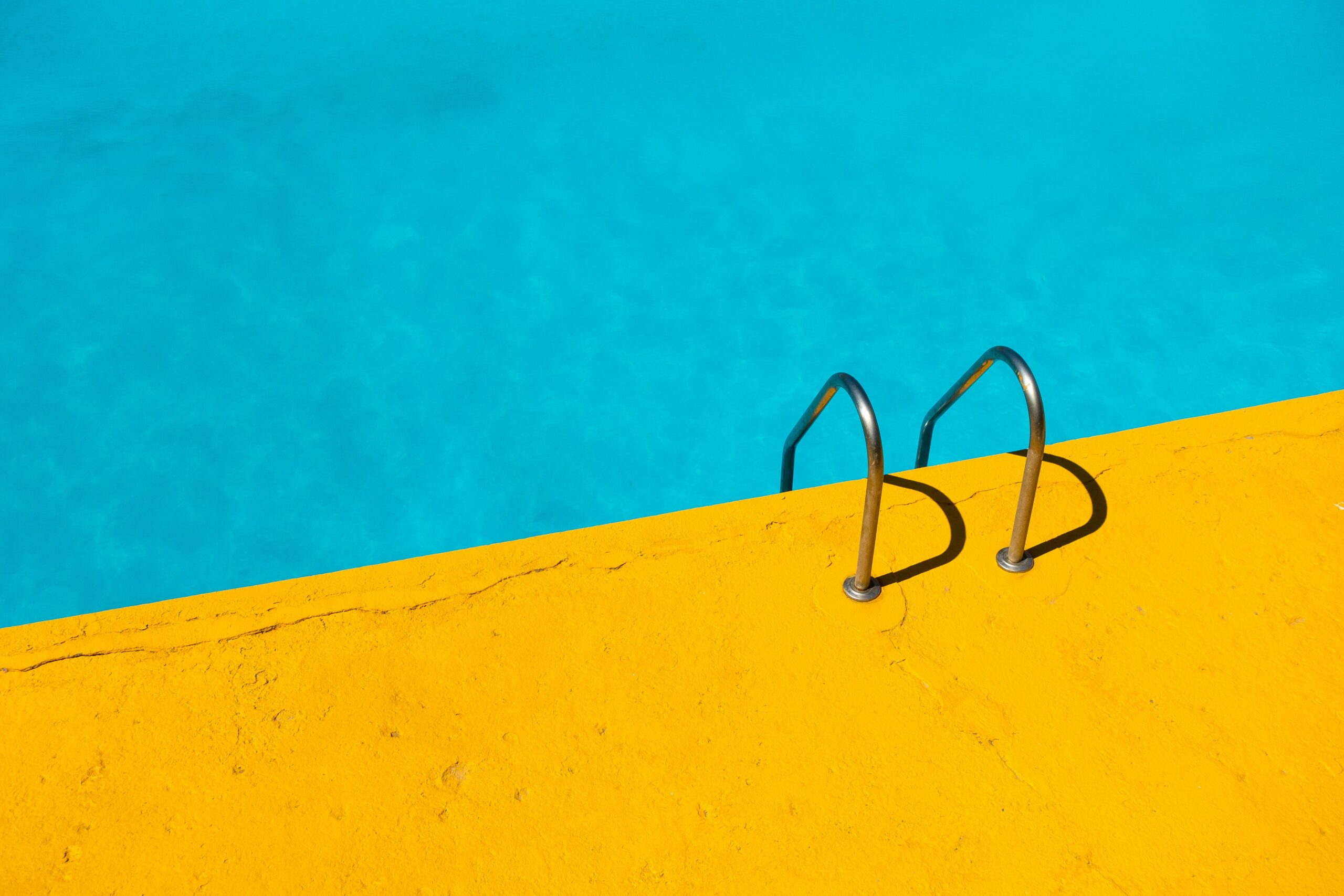 a turquoise pool with a bright yellow border