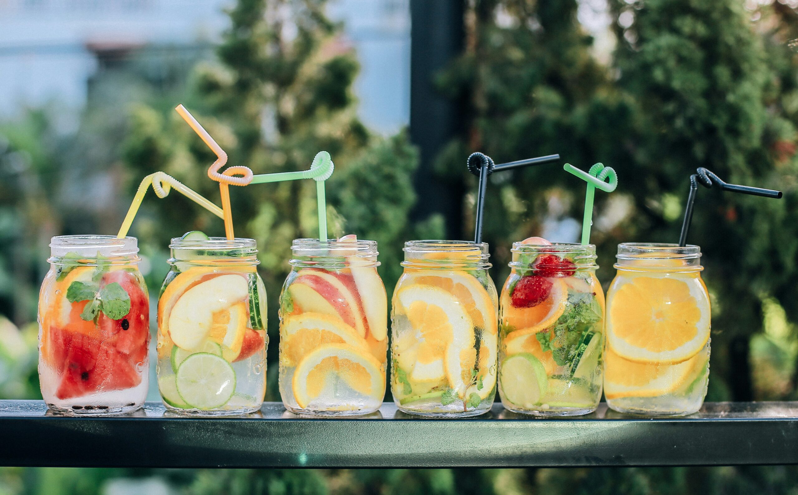 summer drinks in mason jars lined up on a table