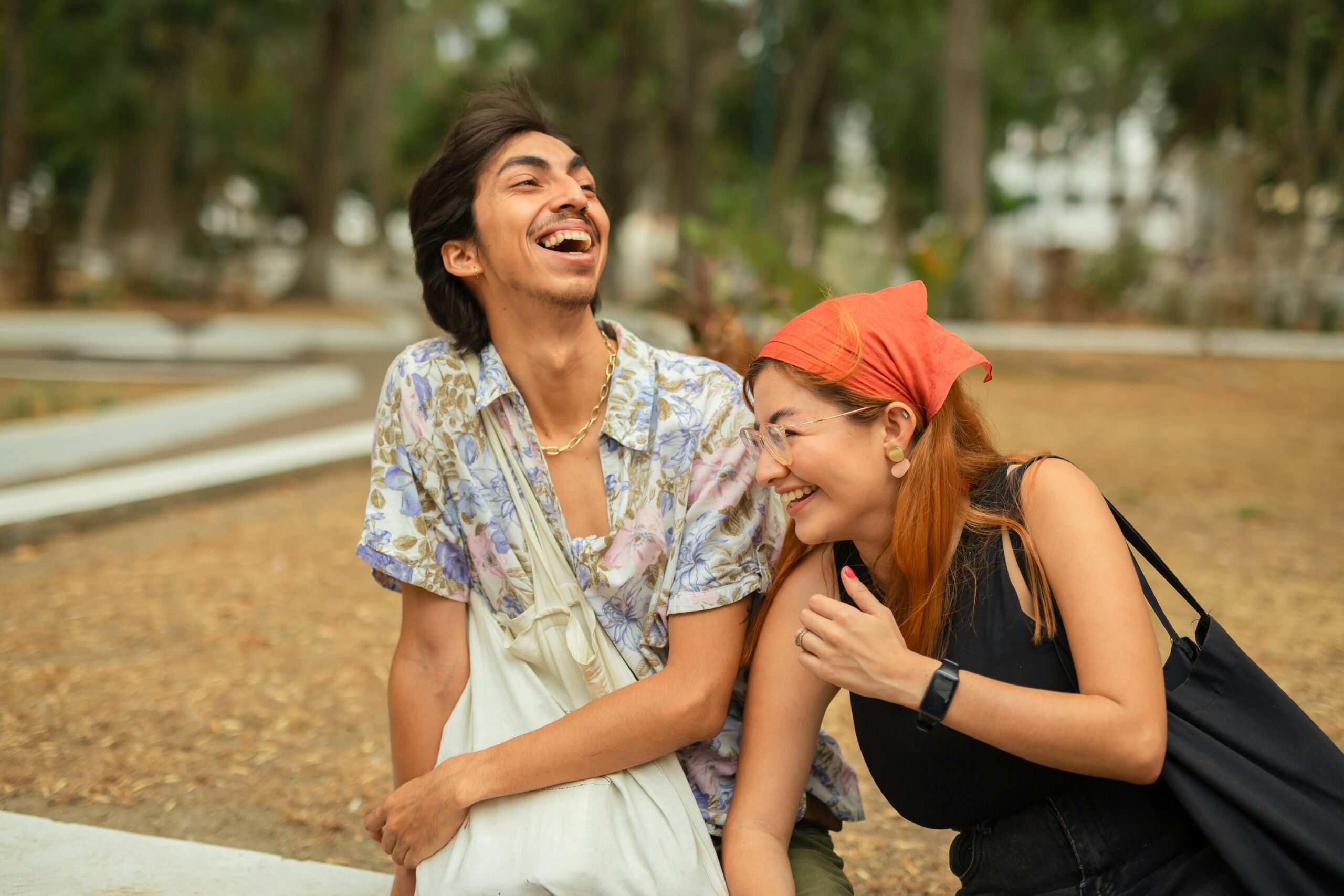 two young people laugh in the park 