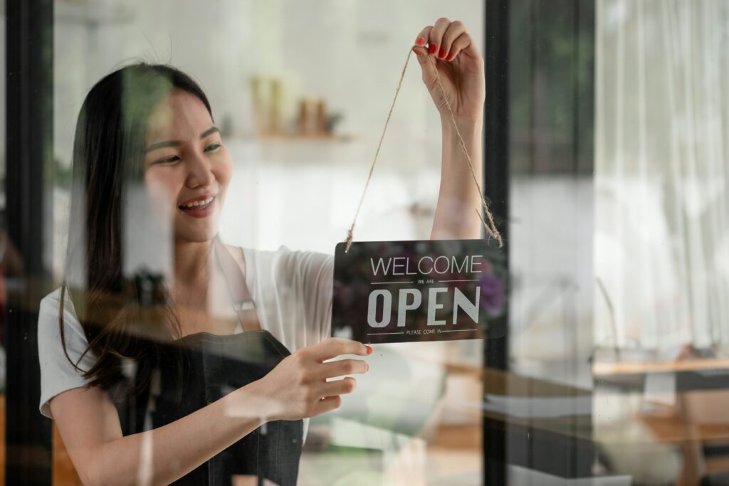 a small business owner flips her sign from closed to open